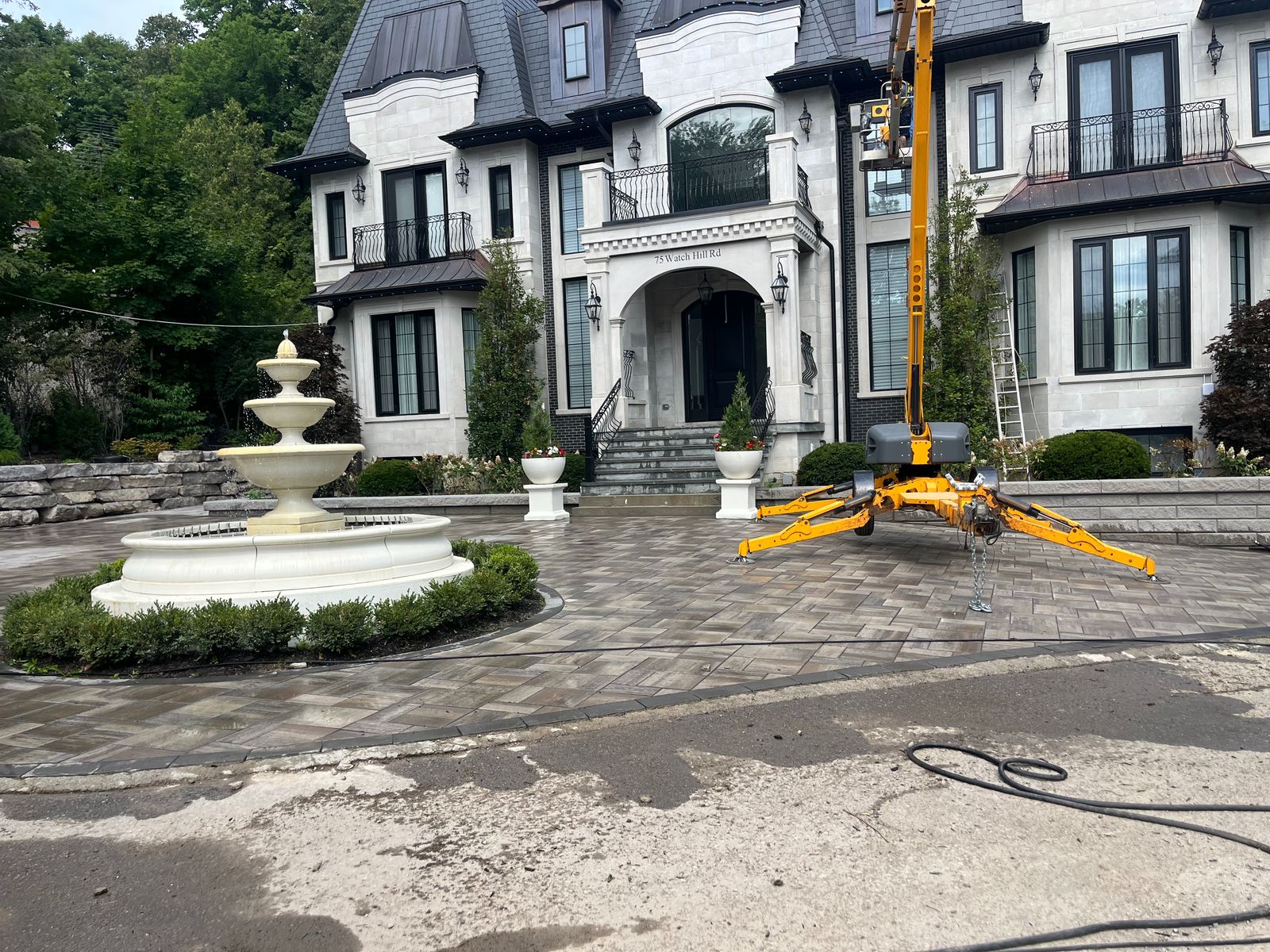 A large residential property with a clean driveway and fountain